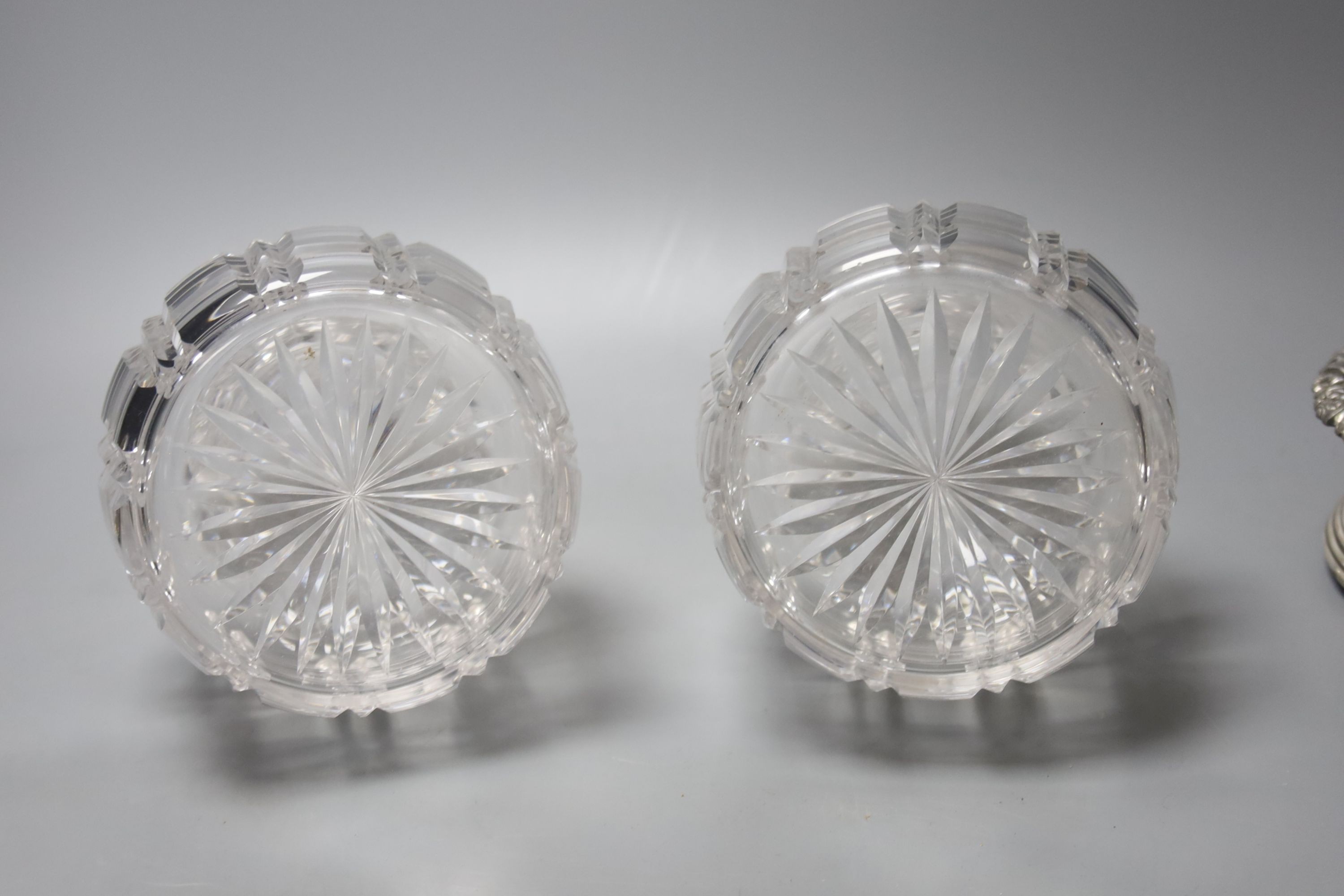 A pair of silver plated coasters with cut glass decanters. 20cm